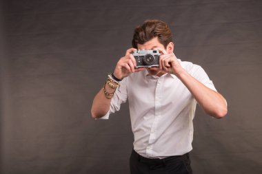 Teknoloji, fotoğraf ve hobi kavramı - retro kamera, kopya alanı ile gri arka plan üzerine size bir fotoğraf çekici adamla