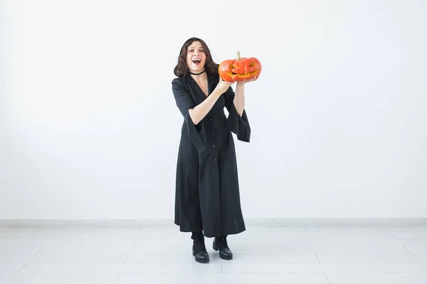 Halloween en maskerade concept - grappige jonge vrouw met pompoen Jack-o-lantaarn. — Stockfoto