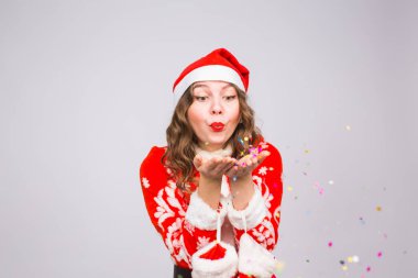 Tatil, Noel ve insanlar kavramı - Noel Baba kostüm konfeti üzerinde beyaz arka plan üzerinde güzel ve genç kadın