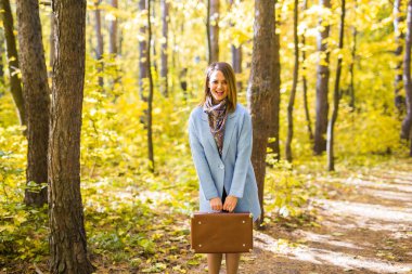 İnsanlar, sezon ve doğa kavramı - çanta sonbahar parkta yürüyen genç kadın