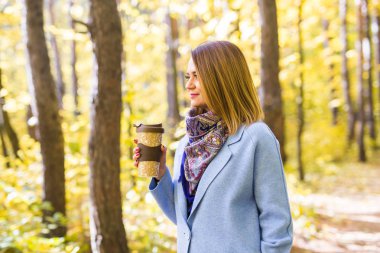 Paket servisi olan restoran kahve bir fincan sonbaharda sokak tutan çekici kadın