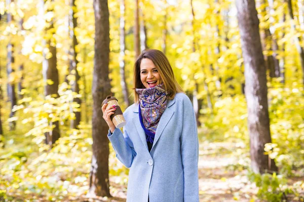 Autumn, drinks and people concept - Woman holding cup of hot drink