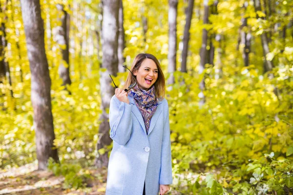 Concepto de naturaleza, estación y gente - mujer joven riendo en el parque de otoño — Foto de Stock