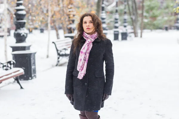 Stad, seizoen en mensen concept - mooie jonge vrouw in zwarte jas en roze sjaal in de winter straat — Stockfoto