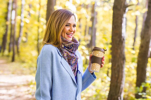 Autumn, drinks and people concept - Woman holding cup of hot drink