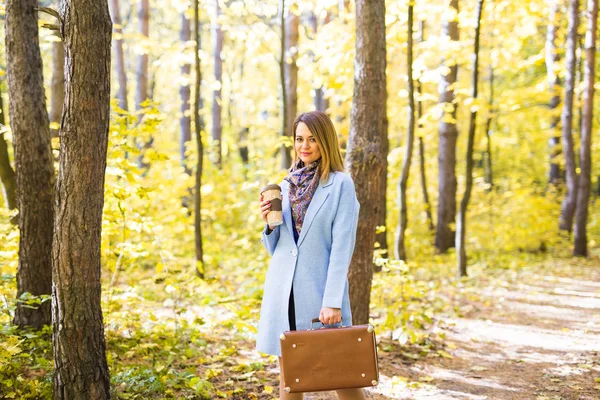 Outono, natureza e conceito de pessoas - Jovem mulher bonita de casaco azul segurando uma xícara de café — Fotografia de Stock