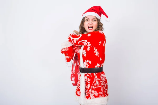 クリスマス、ユーモア、人コンセプト - クリスマスのおもちゃの巨大な袋でサンタ服の女性。彼女は怒りに見える — ストック写真