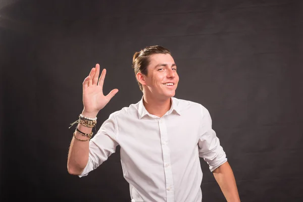 Människor, gest och mode koncept - ung stilig man vifta med handen mot brun bakgrund — Stockfoto