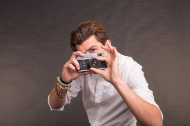 Teknoloji, fotoğraf ve hobi kavramı - retro kamera, sana bir fotoğraf gri arka plan üzerinde çekici adamla