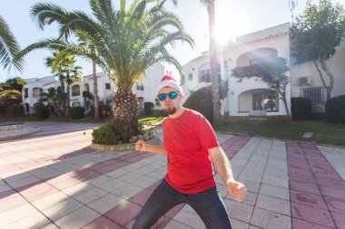 Tatil ve insanlar kavramı - Santa Claus şapka dans genç çekici adam