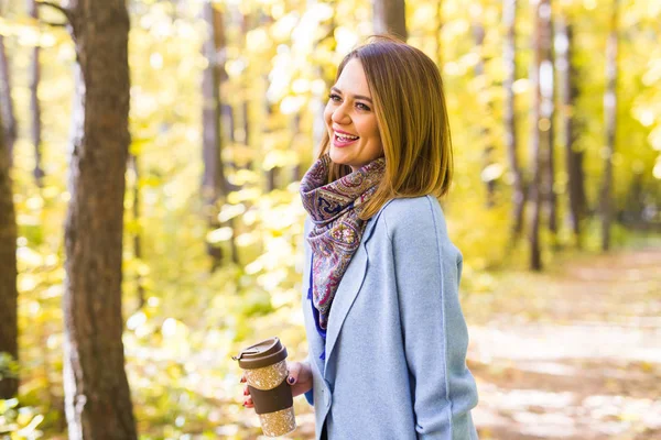 Autumn, drinks and people concept - Woman holding cup of hot drink