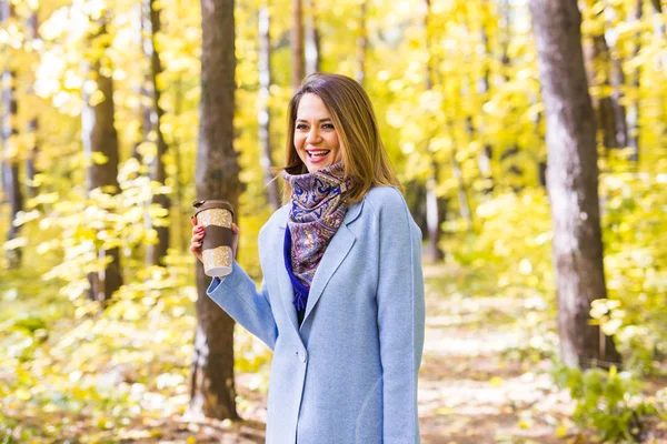 Autumn, drinks and people concept - Woman holding cup of hot drink