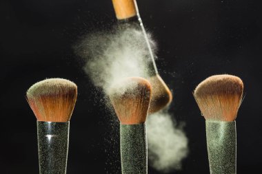 Mineral makyaj ve kozmetik kavramı - uzakta başka bir beyaz toz siyah arka plan üzerinde fırça fırça