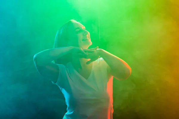 Primo piano di danza giovane donna su sfondo colorato — Foto Stock