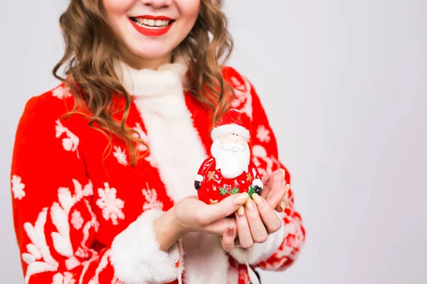Weihnachten, Feier, Menschen-Konzept - Nahaufnahme einer Frauenhand, die eine Weihnachtsfigur auf weißem Hintergrund hält — Stockfoto