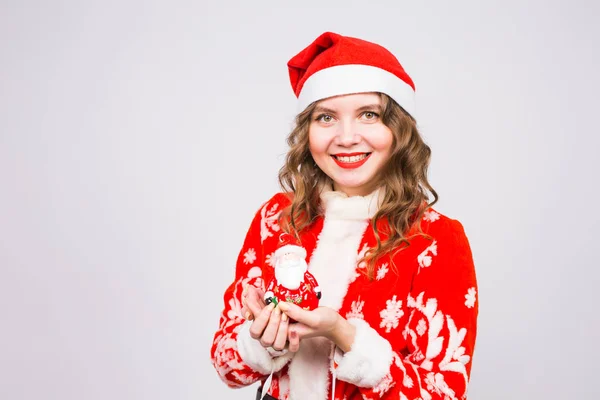 Noel, kutlama, insanlar kavramı - Santa heykelcik beyaz arka plan üzerinde tutarak Santa kostüm komik kadın — Stok fotoğraf