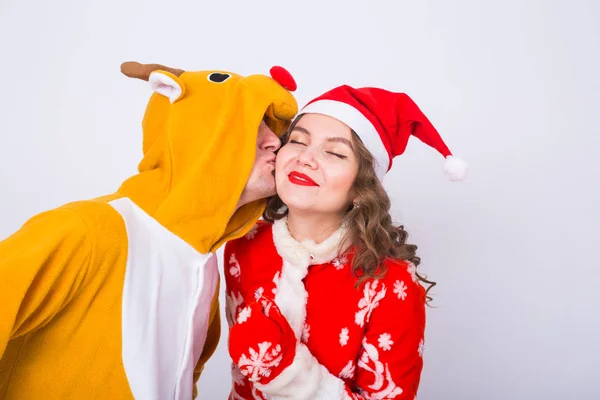 Joyeux jeune femme en santa claus chapeau et homme en costume de carnaval de cerf. Fun, vacances, blague et concept de Noël — Photo