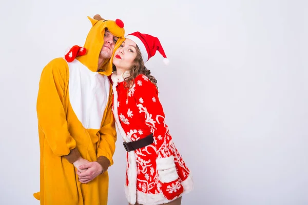 Vacances, Noël et concept de carnaval - Couple drôle en costume de cerf et costume de Père Noël ont du plaisir sur fond blanc avec espace de copie — Photo