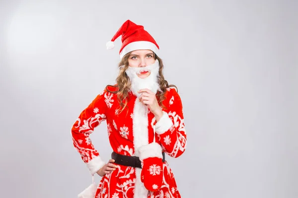 Natal, feriados e emoções conceito - mulher zangada ruim em traje de santa com barba falsa no fundo branco com espaço de cópia — Fotografia de Stock