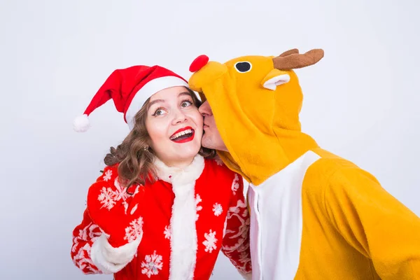 Jovem feliz em chapéu de Papai Noel e homem em traje de carnaval de veados. Divertimento, férias, brincadeira e conceito de Natal — Fotografia de Stock
