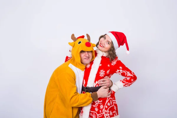 Vacances, Noël et concept de blague - Homme drôle en costume de cerf et femme en costume de Père Noël sur fond blanc — Photo