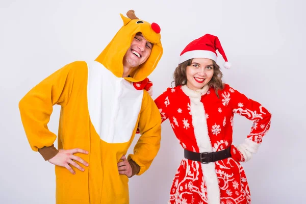 Szczęśliwa młoda kobieta w santa claus kapelusz i człowiek w karnawał kostium jeleni. Koncepcja zabawy, wakacje, żart i Boże Narodzenie — Zdjęcie stockowe