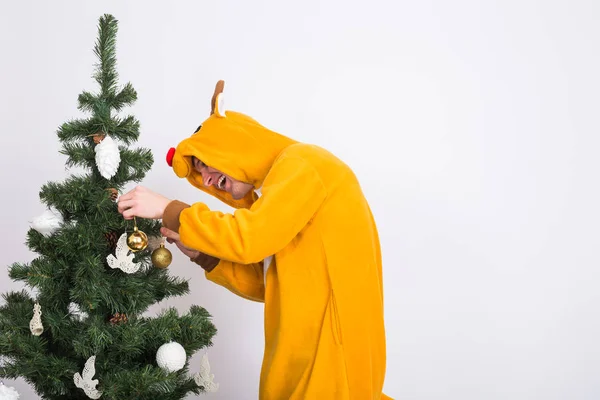 Şaka, Noel, insanlar kavramı - erkek geyik kostüm xmas ağacı beyaz arka plan üzerinde dekorasyon — Stok fotoğraf