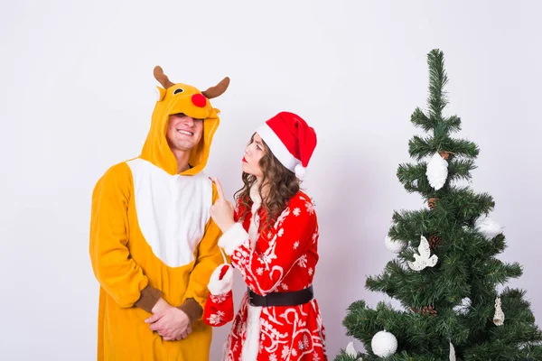 Les gens, la famille et le concept de Noël - beau couple en costumes de Noël près de l'arbre de Noël sur fond blanc . — Photo