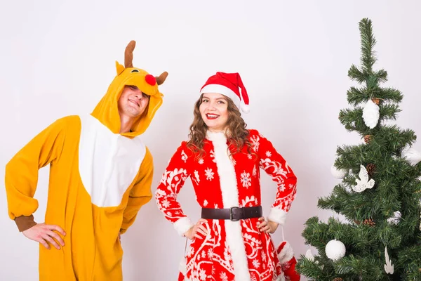 Les gens, la famille et le concept de Noël - jeune couple en costume de père Noël et cerf sur fond blanc — Photo