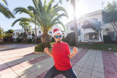 Tatil ve insanlar kavramı - Santa Claus şapka dans genç çekici adam