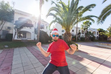 Tatil ve insanlar kavramı - Santa Claus şapka dans genç çekici adam