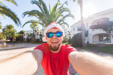 Noel, eğlence ve tatil kavramı - selfie alarak Noel geyik boynuzları giyen adam