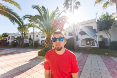 Tatil ve insanlar kavramı - Noel geyik boynuzları açık havada gülümseyen genç çekici adam