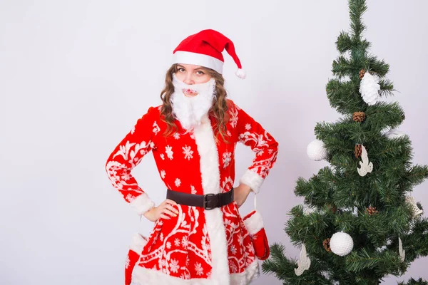 Xmas giyen içinde kız santa Noel ağacı arka plan üzerinde kostüm. Bayram, şaka ve insanlar kavramı — Stok fotoğraf