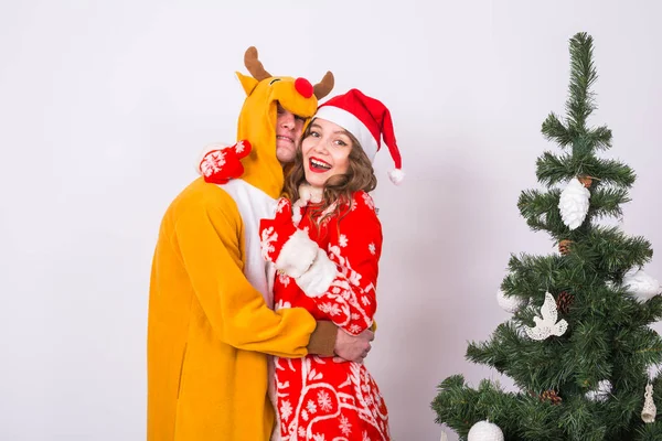 Vacances, Noël et les émotions concept - beau couple en costumes de Noël étreignant sur fond blanc — Photo