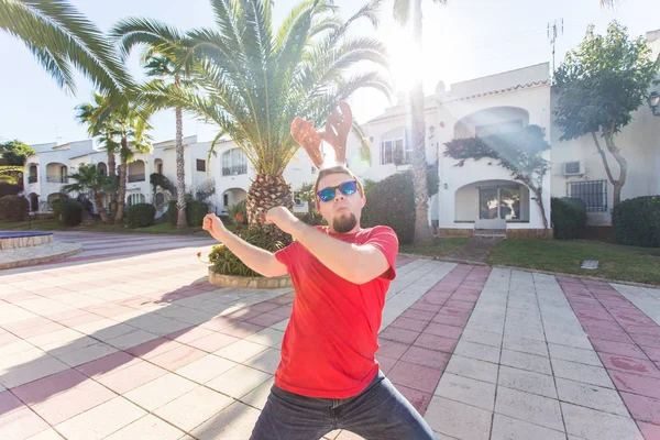 Tatil ve insanlar kavramı - Noel geyik boynuzları açık havada dans komik adam