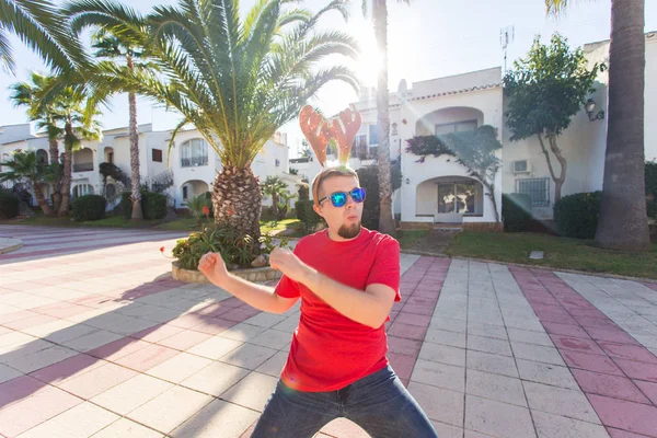 Noel, eğlence ve tatil kavramı - Noel geyik boynuzları dans giyen adam