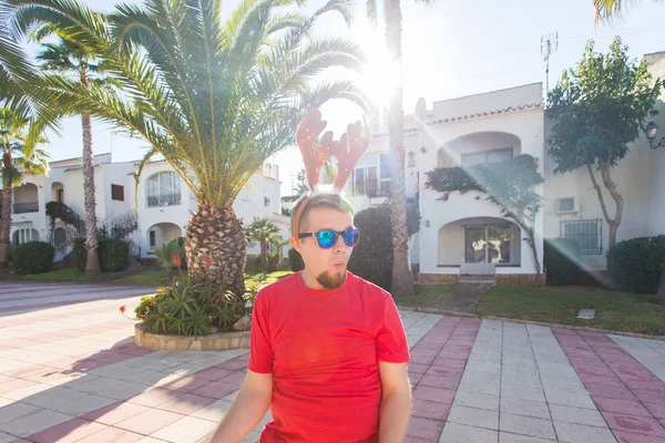 Tatil ve insanlar kavramı - Noel geyik boynuzları açık havada dans komik adam