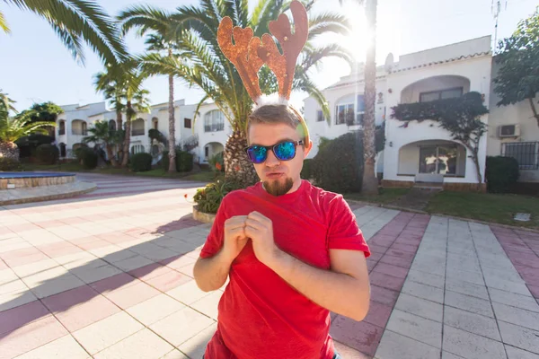 Noel, eğlence ve tatil kavramı - Noel geyik boynuzları dans giyen adam