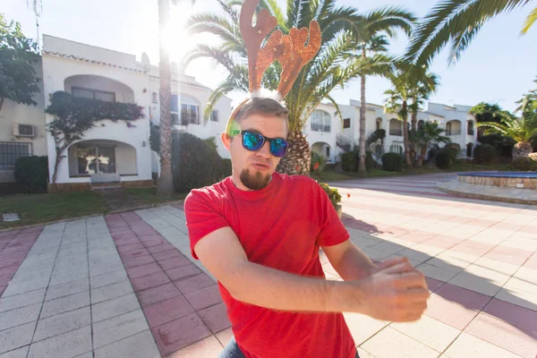 Tatil ve insanlar kavramı - genç çekici adam Noel geyik boynuzları içinde dans