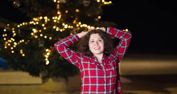 Διακοπές και οι άνθρωποι έννοια - όμορφη εύθυμη νεαρή γυναίκα κοντά στο χριστουγεννιάτικο δέντρο τη νύχτα — Φωτογραφία Αρχείου