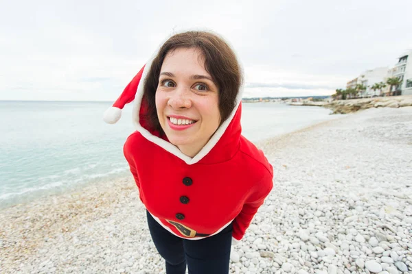Noel ve tatil kavramı - komik kadın fan deniz arka plan üzerinde sahip Noel Baba kostüm — Stok fotoğraf