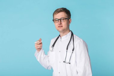 Doktor sigara içmeyi mavi arka plan üzerinde vurguladı