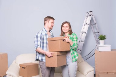 Aile, yeni daire, duygu ve tehcir kavramı - kutuları tutan genç mutlu insanlar. Yeni bir daire içinde hareket