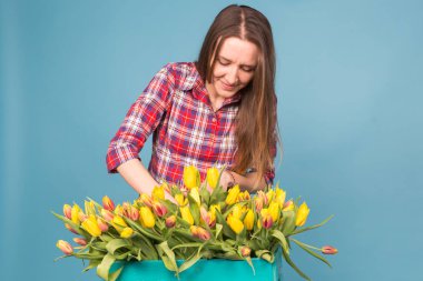 Kadın çiçekçi sıralar Lale kutusunun dışarı büyüleyici seçer onları için gelecekteki çiçek düzenleme