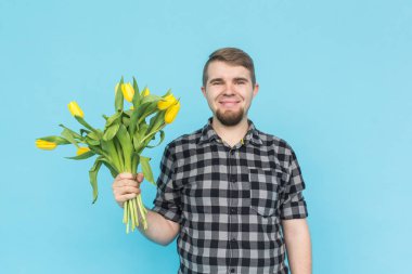 Grup mavi zemin üzerine sarı laleler ile beyaz yakışıklı adam.