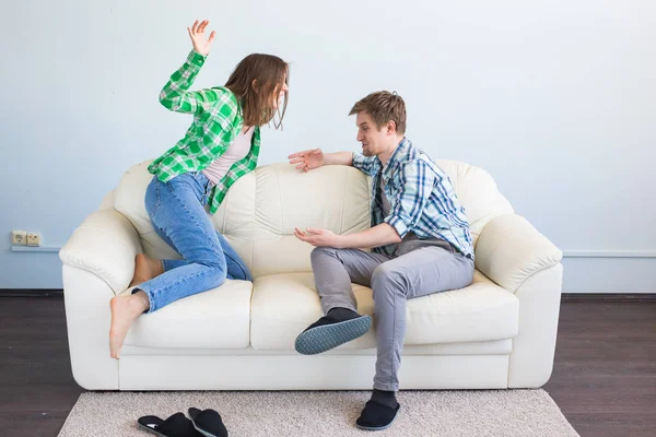 Mal concepto de relación. Pareja joven sentada en el sofá en casa discutiendo, esposa ofendida y marido infeliz —  Fotos de Stock