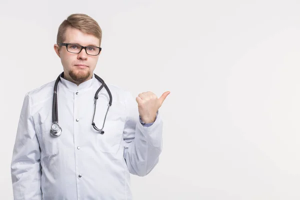 Médico masculino apontando o dedo para o espaço de cópia, isolado em fundo branco. Conceito médico . — Fotografia de Stock