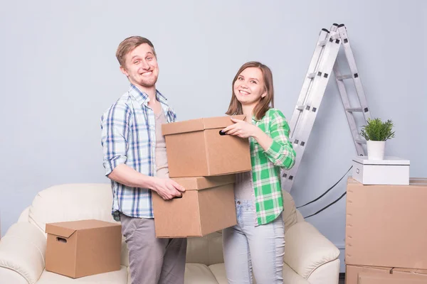 Família, novo apartamento, emoções e conceito de realocação - par de jovens felizes segurando caixas. Mudar-se para um novo apartamento — Fotografia de Stock