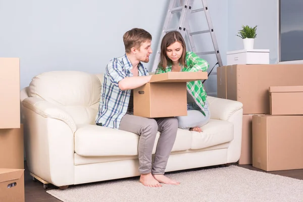 Переезд, новая квартира и переезд - счастливая пара, открывающая свою коробку вместе из-за переезда в новую квартиру — стоковое фото